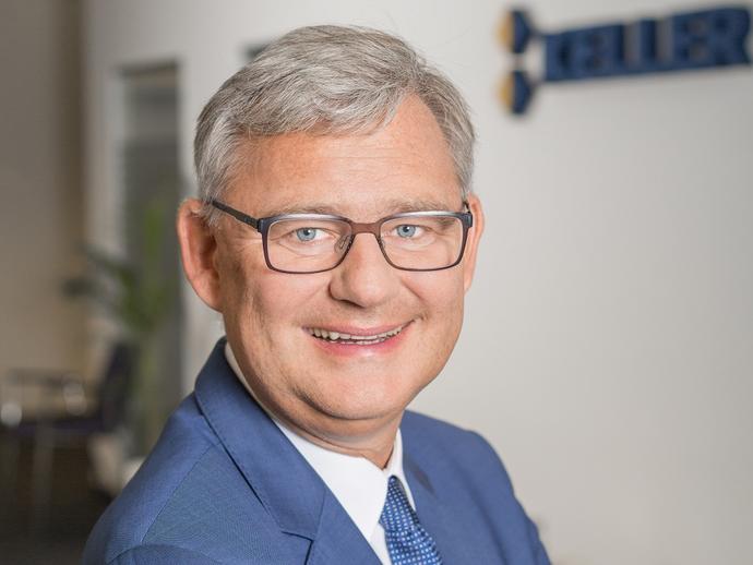 male employee in blue suit and glasses in office